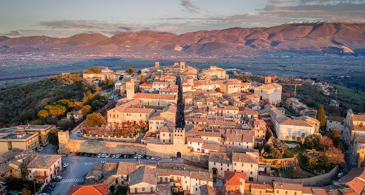 Suggestiva vista aerea di un borgo antico circondato da dolci colline verdi.