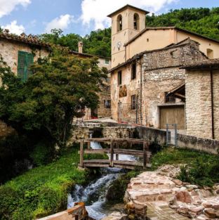 Un tranquillo angolo di Umbria con un paesaggio semplice, in cui si notano edifici storici e spazi verdi.