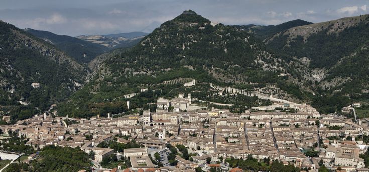 Panorama di una tipica scena umbra con colline verdi e piccoli borghi. Una vista serena sull'entroterra.