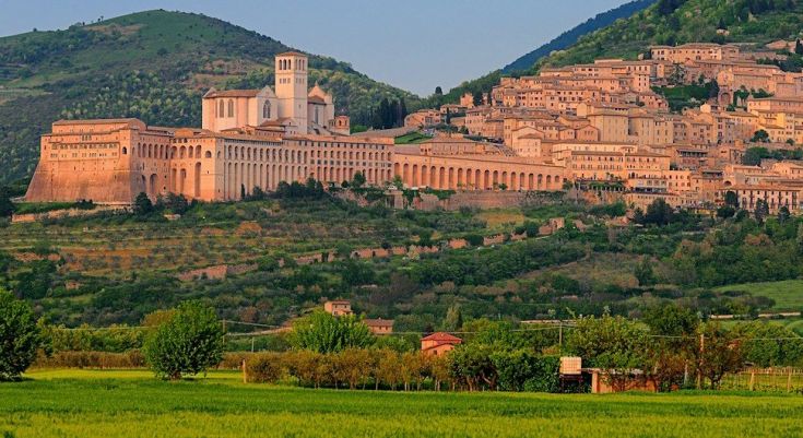 Panorama di Assisi con la Basilica di San Francesco immersa nel verde circostante.