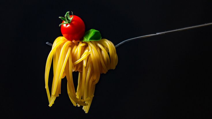 Un piatto di spaghetti con pomodoro fresco e basilico, servito in modo semplice e invitante.