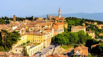 Panorama di un centro storico con edifici colorati e spazi verdi nelle vicinanze.