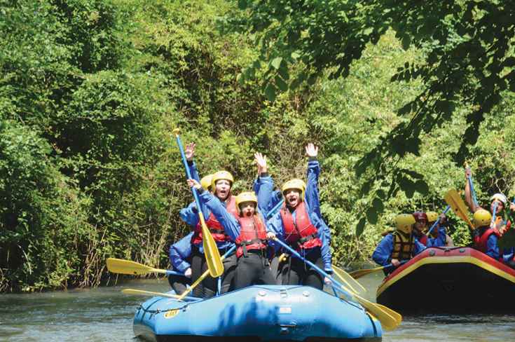 Un gruppo di persone che si diverte a praticare rafting in un ambiente naturale.