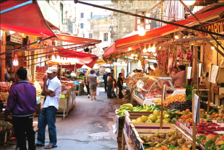 Un mercato locale vivace con frutta e verdura fresche, caratterizzato da bancarelle colorate.