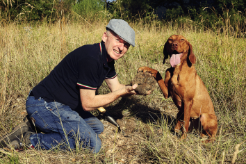 Un uomo e il suo cane esplorano un ambiente naturale, lieti di aver scoperto un tesoro.