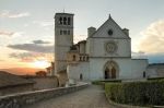 La Basilica di San Francesco a Assisi illuminata da un tranquillo tramonto.