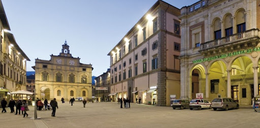 Una scena serale della piazza, caratterizzata da architetture storiche e un'atmosfera tranquilla.