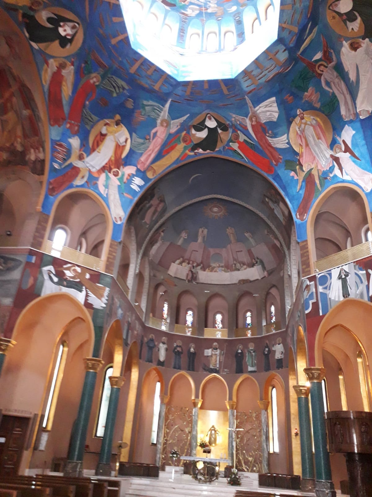 Interno della Basilica Santa Rita da Cascia con colori che evocano un senso di sacralità e dettagli architettonici.