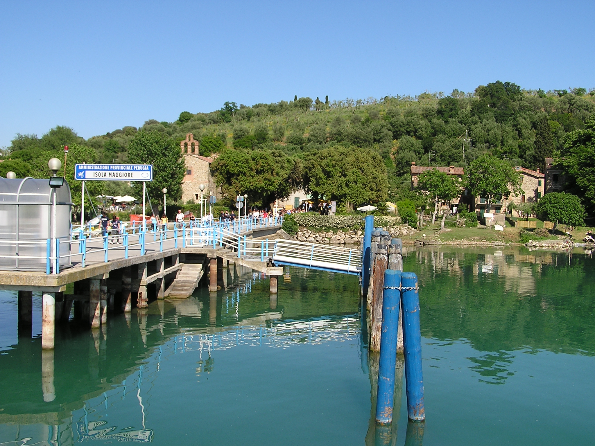 Un panorama del molo a Isola Maggiore, con il lago che riflette come uno specchio il cielo sereno.