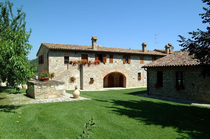 Un casolare, circondato da un giardino ampio, caratterizzato da una semplice architettura in pietra.