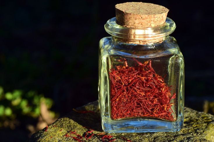 Barattolo di vetro con zafferano, una spezia dal colore rosso scuro e dal profumo distintivo.