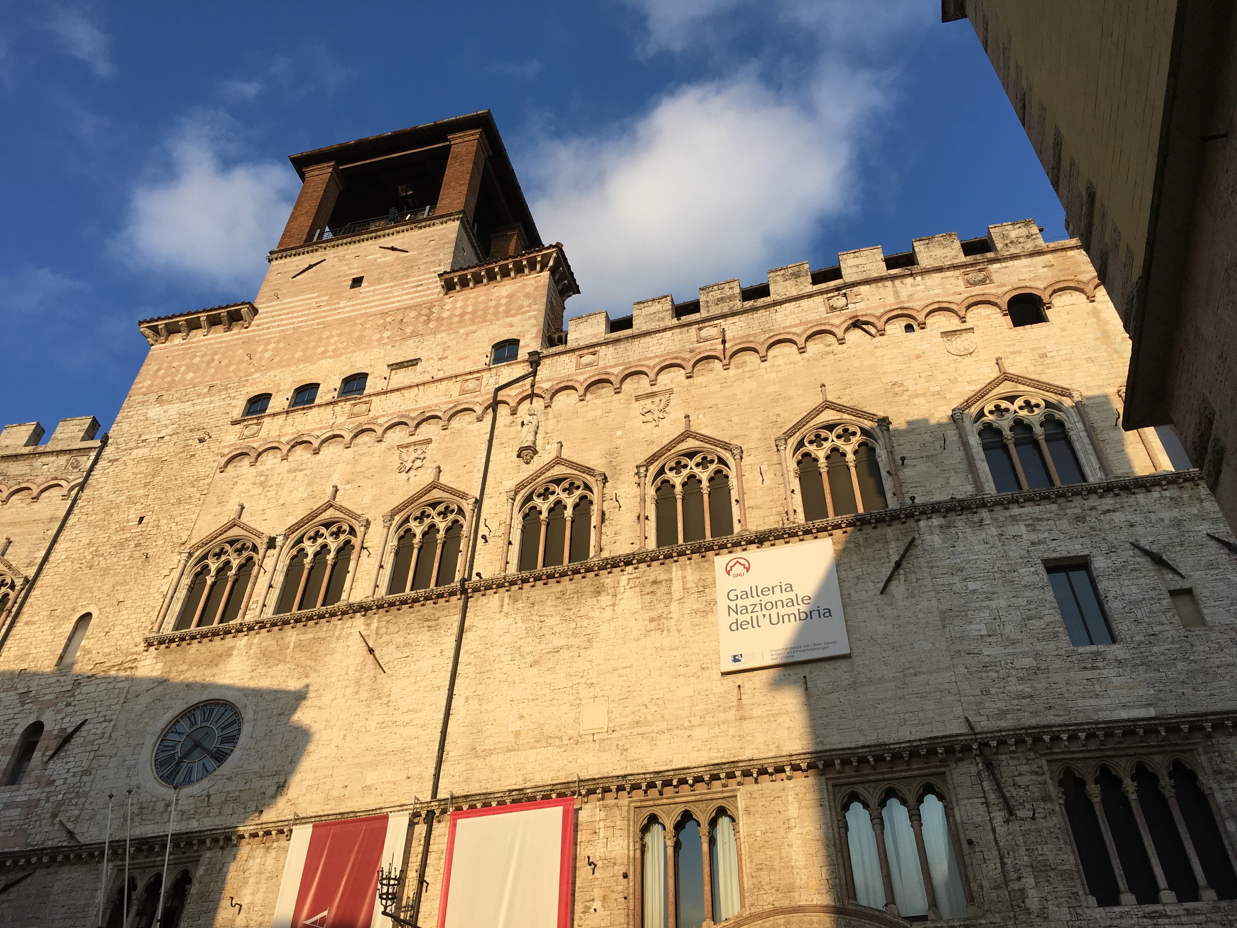 La Galleria Nazionale dell'Umbria si trova con la sua facciata e finestre gotiche, sotto un cielo sereno.