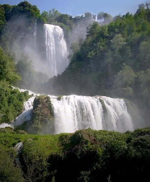 Immagine della cascata delle Marmore in una vegetazione ricca.