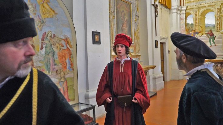 Un momento di discussione tra artisti rinascimentali in un palazzo storico.