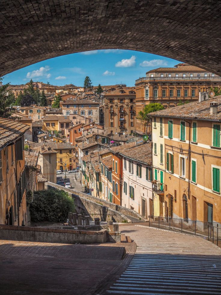 Scena di strade tranquille, con palazzi storici e un cielo sereno che conferisce un'atmosfera calma.