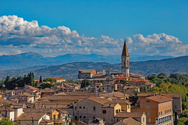Un panorama di un caratteristico di Perugia circondato da colline e un cielo sereno.