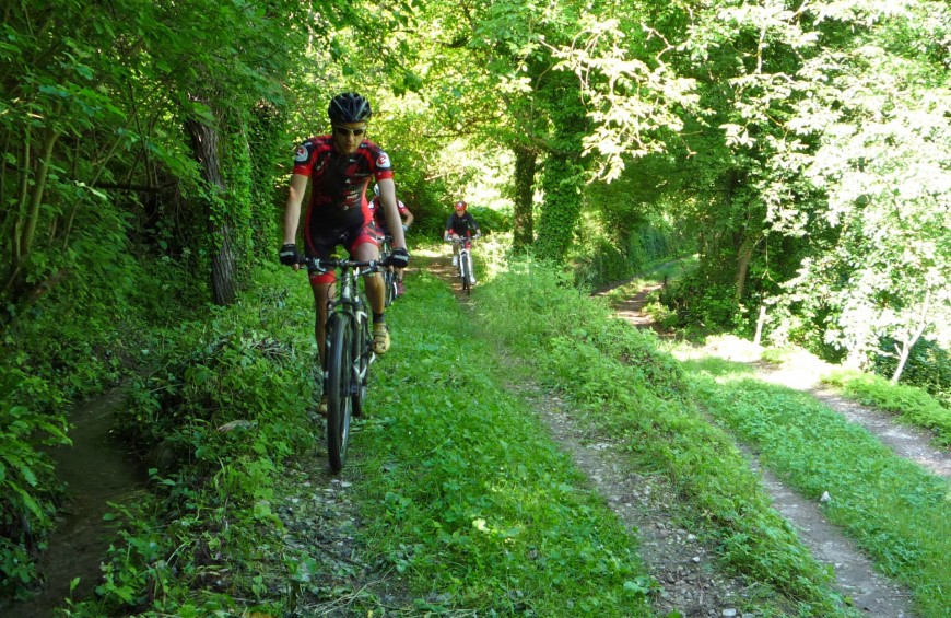 Due ciclisti percorrono un sentiero nel bosco lungo l'ex ferrovia Spoleto Norcia.