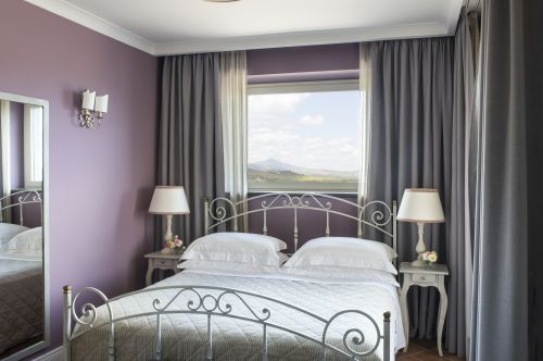 Camera luminosa con panorama sul verde circostante e un'atmosfera rilassante.