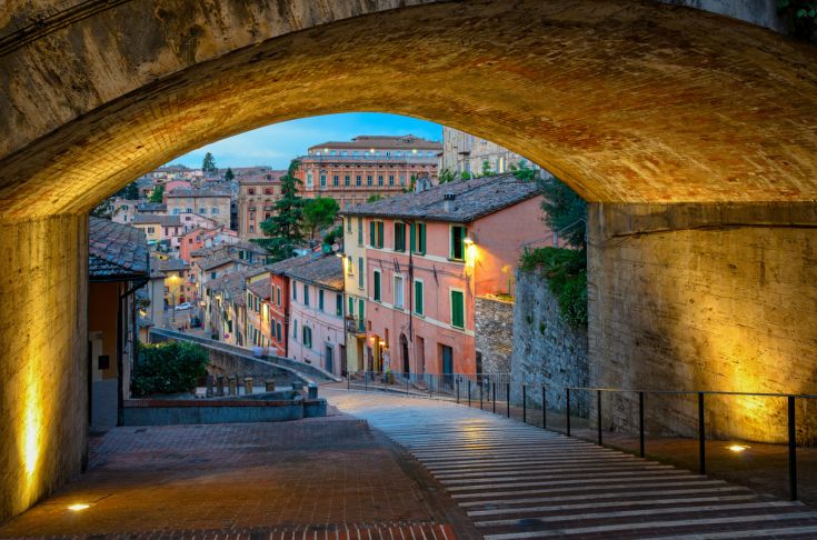 Uno scorcio di una strada illuminata con case dai colori vivaci in Umbria.