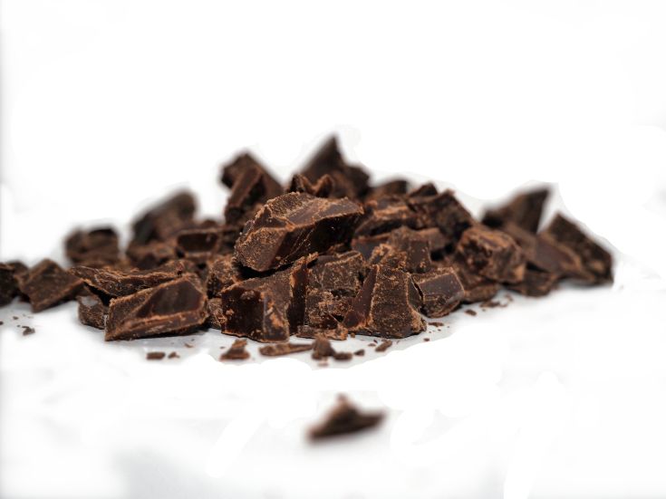 Fette di cioccolato fondente su uno sfondo bianco, un ingrediente gustoso per preparazioni dolci.