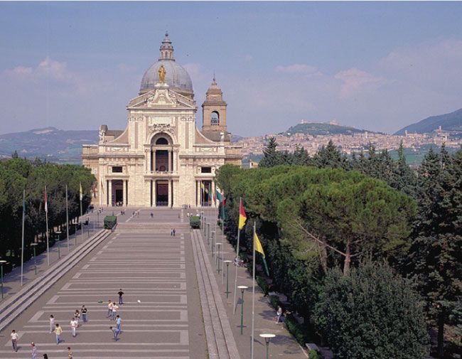 Immagine della Chiesa di Santa Maria degli Angeli, circondata da alberi e vegetazione.