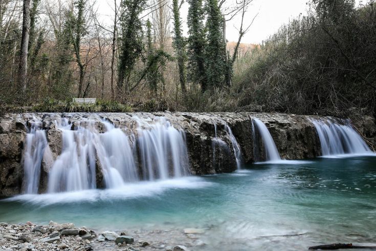 Una scena tranquilla di una cascata circondata da vegetazione verde.