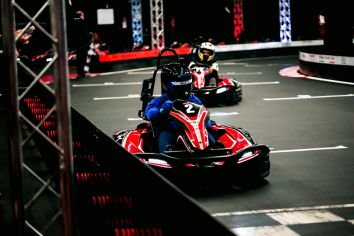 Scena vivace di go-karting, con piloti pronti a competere su una pista al coperto.