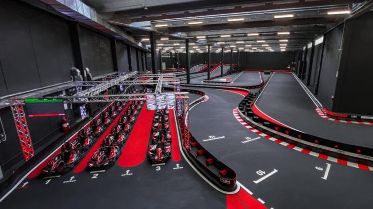 Una pista da go-kart moderna con automobili disposte in modo ordinato e un design funzionale.