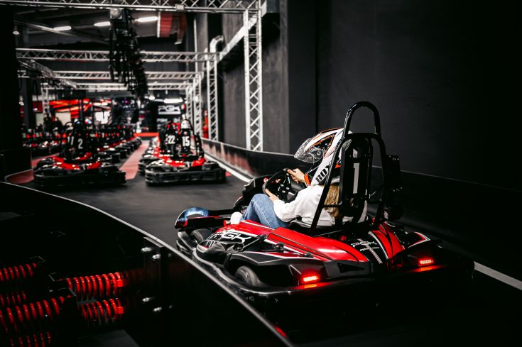 Un'esperienza di go-kart su una pista con auto di colore rosso e nero, adatta per chi cerca emozioni forti.