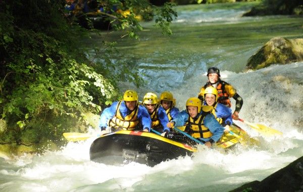 Un gruppo di avventurieri si destreggia tra le rapide in un’attività di rafting nel cuore della natura.