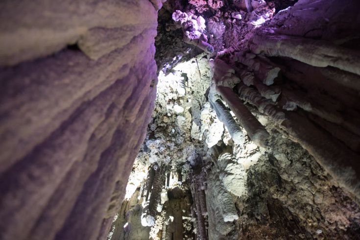 Luce tenue mette in risalto stalattiti e formazioni rocciose all'interno di una grotta interessante.