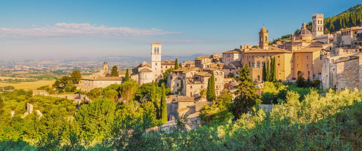 Un panorama su una caratteristica città medievale in Umbria, circondata da verde e colline. 