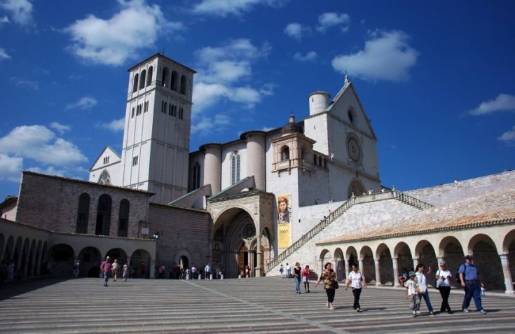 La Basilica di San Francesco, con un cielo sereno e visitatori in piazza.