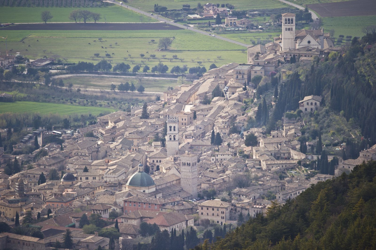 Panorama di una cittadina umbra, immersa nella natura con colline e campagne verdi circostanti.