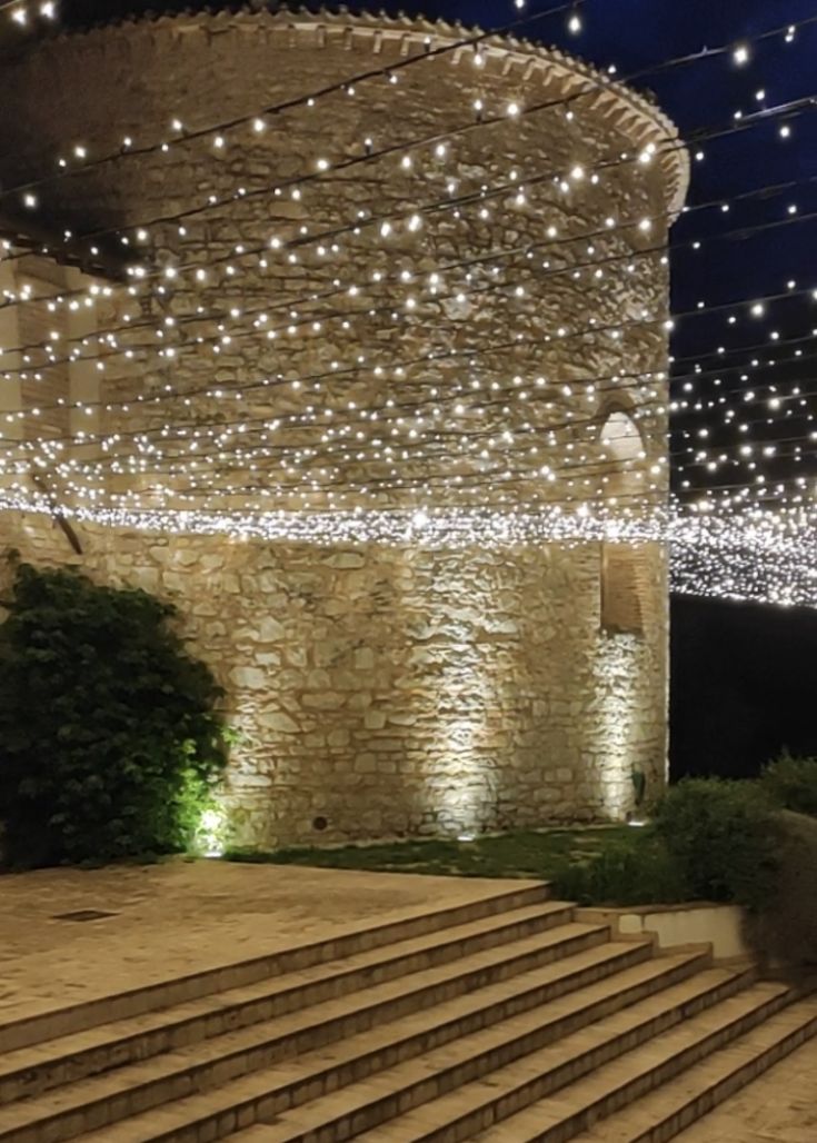 Un'elegante scena notturna con luci brillanti che illuminano un palazzo in pietra.