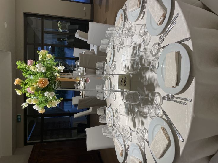 Tavolo decorato con fiori e dettagli semplici, pronto per un evento particolare.