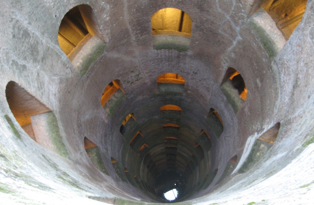 L'interno del pozzo di San Patrizio, caratterizzato da pareti in pietra e aperture sui lati.