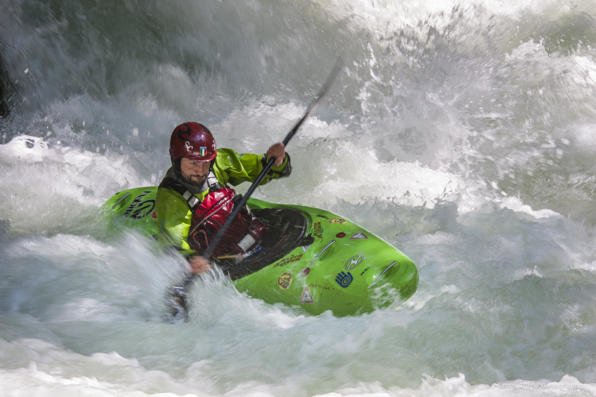 Una persona in Kayak affronta le onde di un fiume, mostrando abilità e controllo. La scena riflette l'energia dell'acqua in movimento.