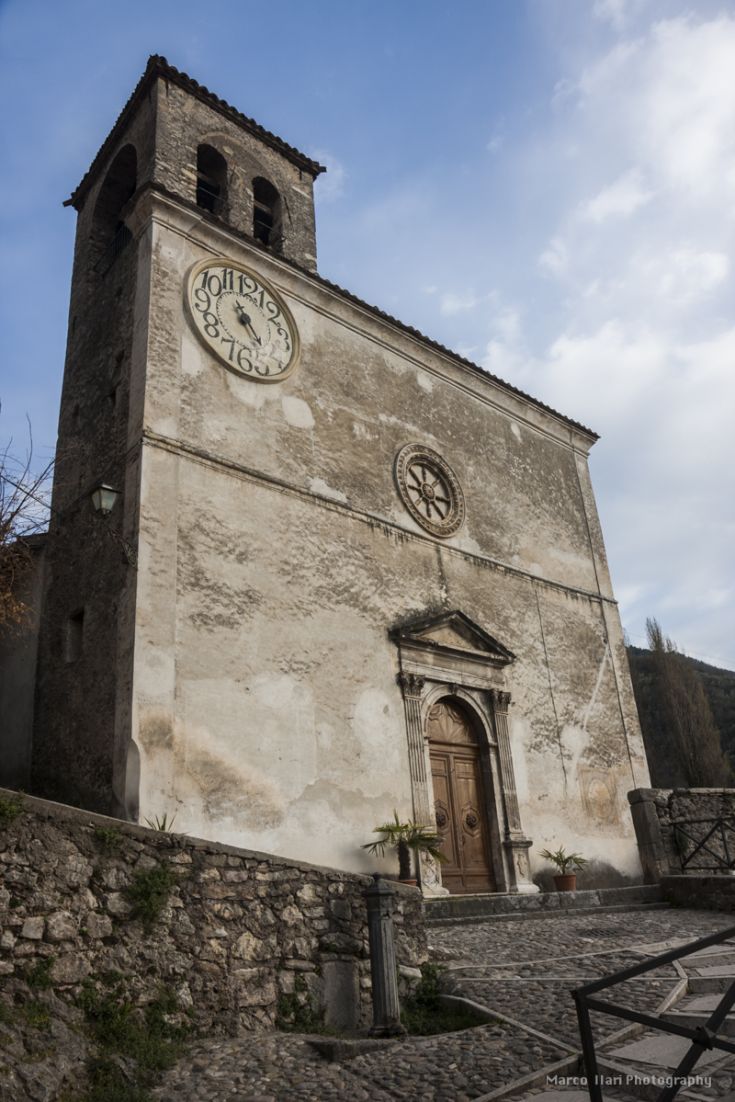 Facciata di una chiesa storica con un grande orologio sul lato sinistro sotto il campanile.