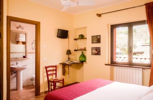 Camera accogliente con elementi essenziali e arredi pratici. Un rifugio nel cuore dell'Umbria.