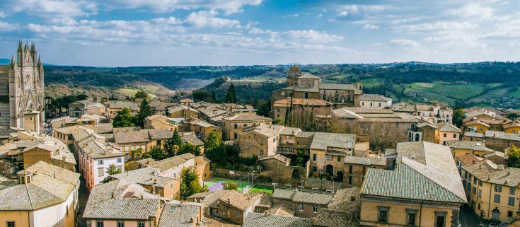 Panorama di un caratteristico comune umbro circondato da dolci colline verdi.
