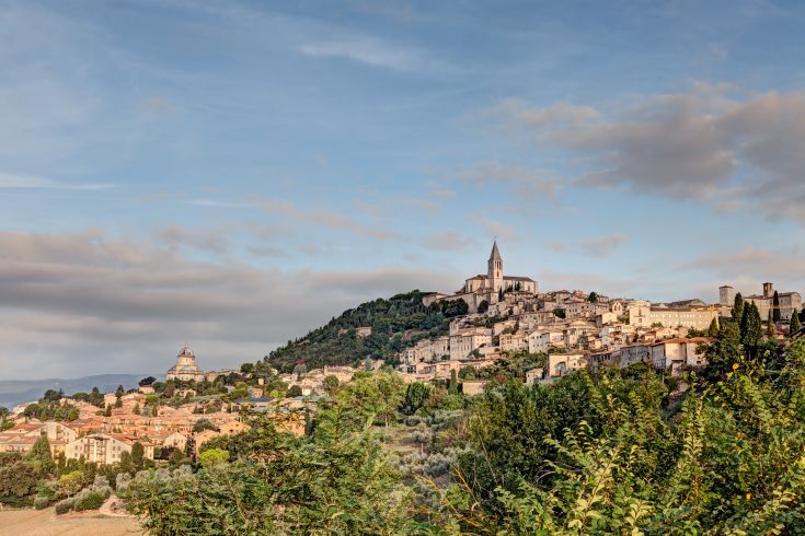 Un panorama di Trevi, caratterizzato da colline verdi e un' architettura storica di pregio.