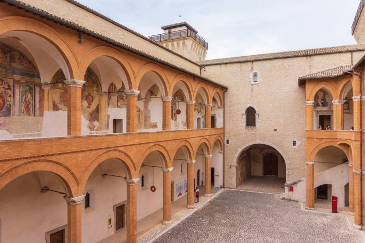 Un chiostro storico con archi e affreschi, rappresenta la cultura umbra in modo caratteristico.