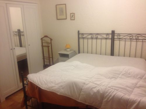 Ambiente di una camera con letto matrimoniale e arredamento essenziale, ideale per momenti di relax.