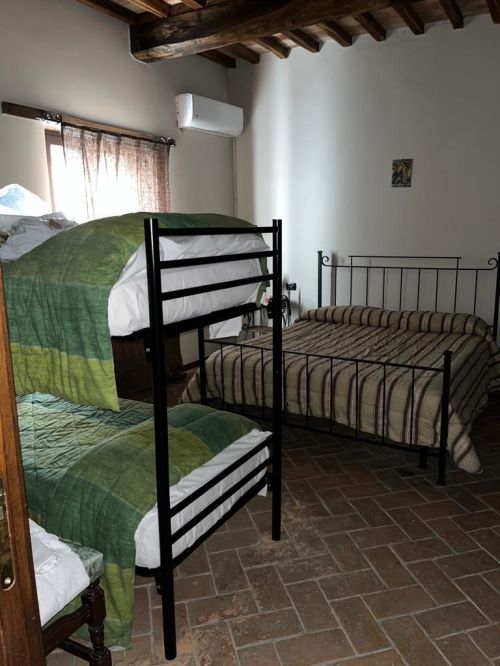 Camera semplice in agriturismo, con letti a castello e letto matrimoniale, dal design rustico.