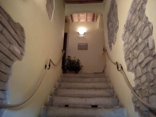 Scale in un agriturismo, con pareti dai toni terra e dettagli in pietra. L'ambiente è semplice e accogliente.