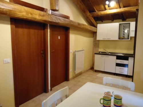 Un accogliente angolo di una cucina in un agriturismo, con porte in legno e caratteristiche rustiche.