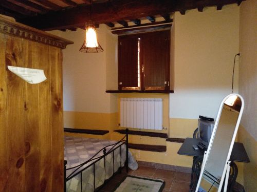 Camera di un agriturismo con arredi in legno e tonalità calde, perfetta per un soggiorno tranquillo.