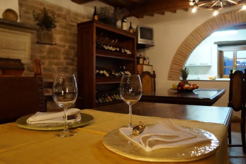 Una sala da pranzo accogliente con tavoli semplici e una cantina di vini ben organizzata.