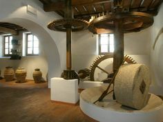 Una sala espositiva con ingranaggi e macchinari di antichi frantoi, rappresentativi dell'artigianato tradizionale dell'Umbria.